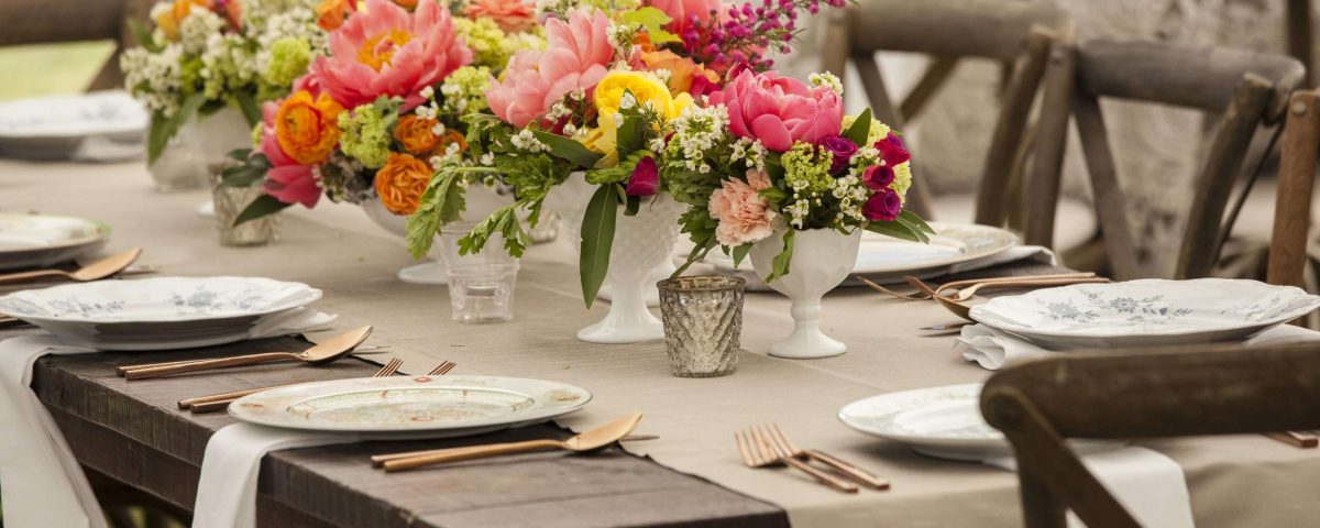 Dinner table with antique dishes and flowers for wedding reception