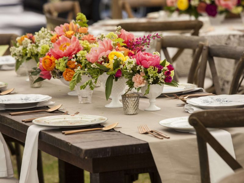 Dinner table with antique dishes and flowers for wedding reception
