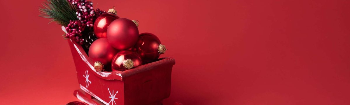 Christmas concept, Red Santa's Sleigh with baubles on a red background, copy space.