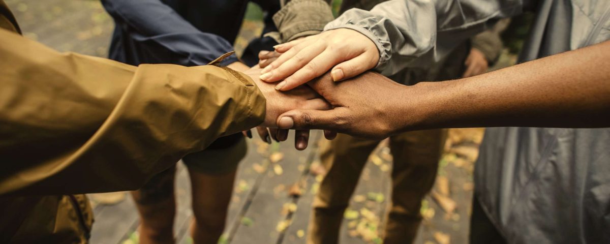 Group of hikers stacking hands